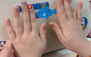 Kids showing off her nail decals printed by phomemo label maker.